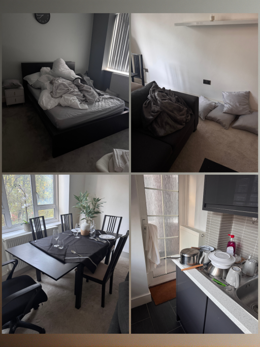 A living space featuring a messy bed, a sofa with cushions, and a dining area.